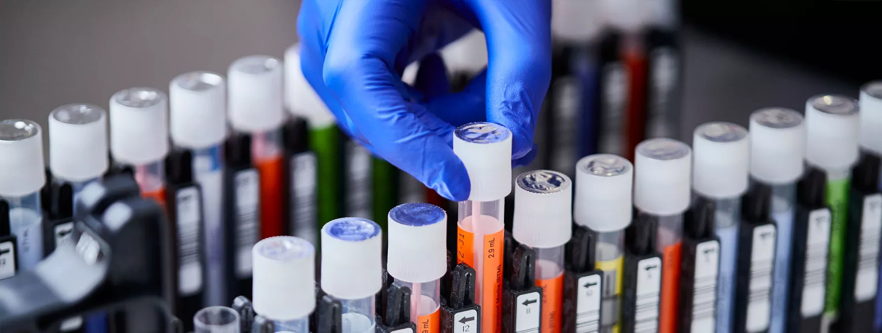 Gloved hand taking out vial from tray