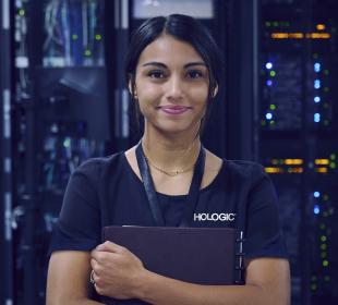 Hologic employee holding folder with infrastructure in background